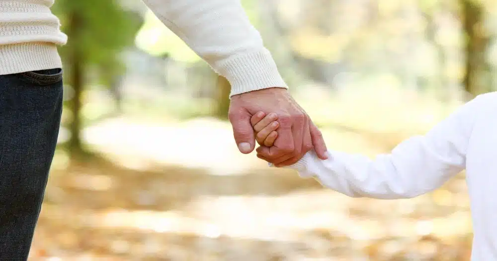 Parent holding a child’s hand outdoors, representing the legal process for modifying child support in Pennsylvania.